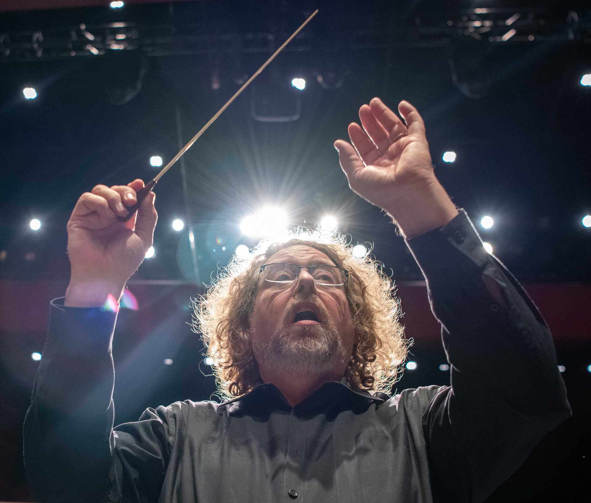 Dr. Lewis conducting with a baton onstage