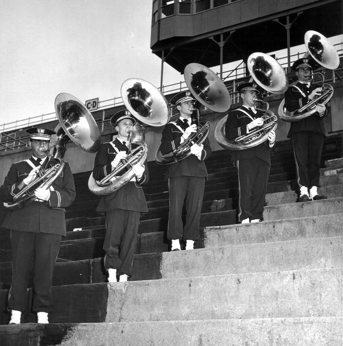 Tuba players standing on the stairs of the stadium stands