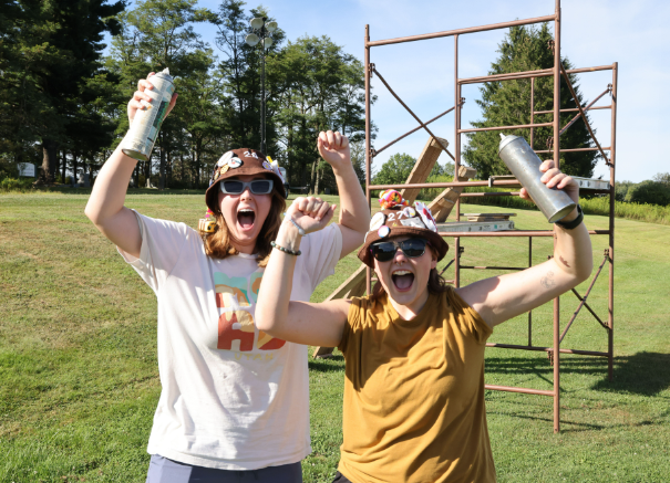 Two excited members with arms raised at band camp
