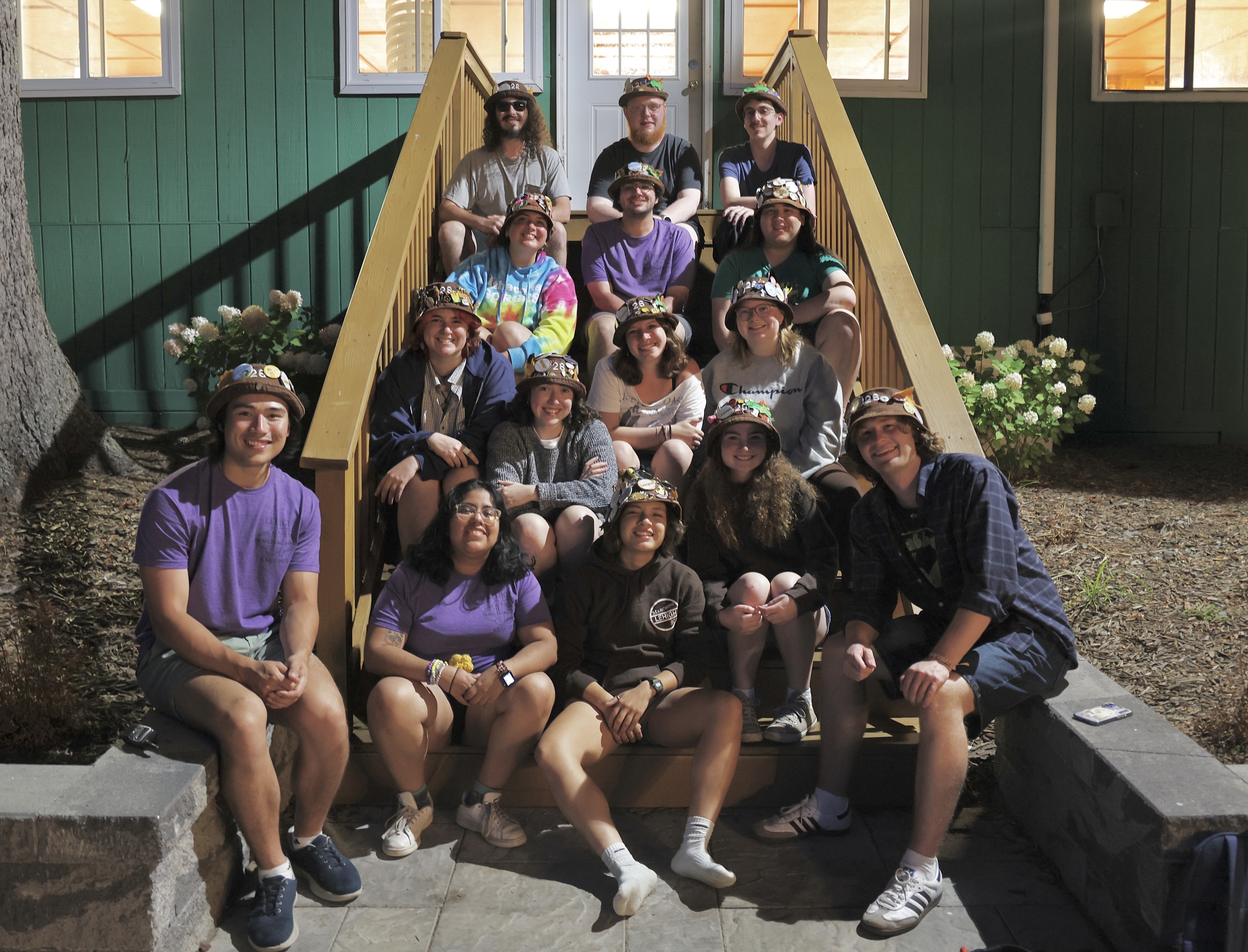 The seniors sitting on the steps of a cabin at band camp
