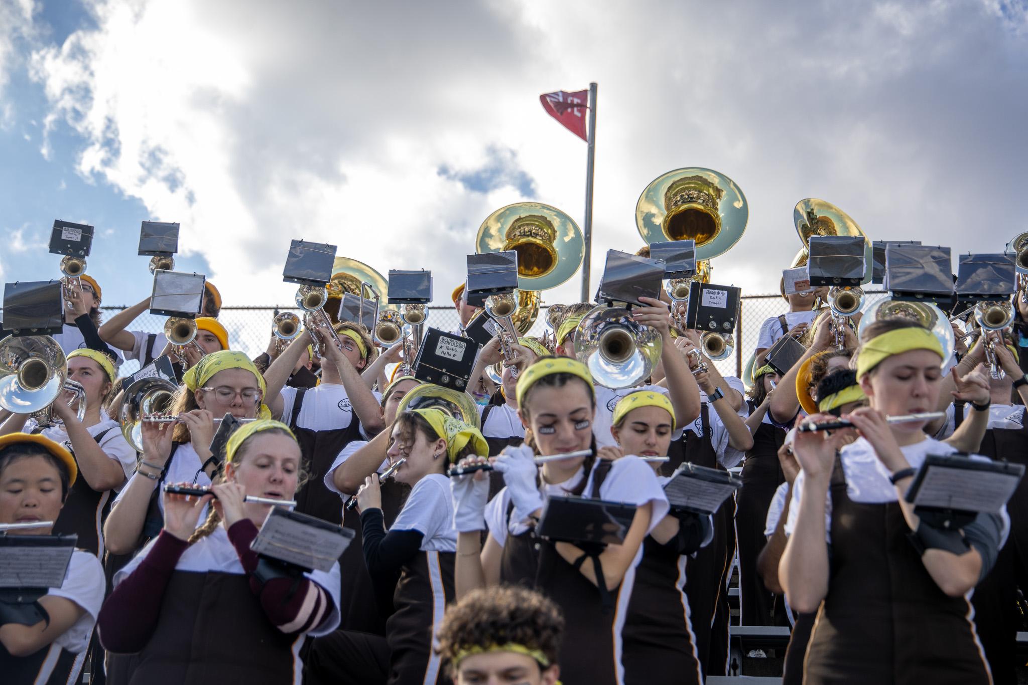 The band in the stands with piccolos in front, and mellophones, trumpets, and sousaphones behind them