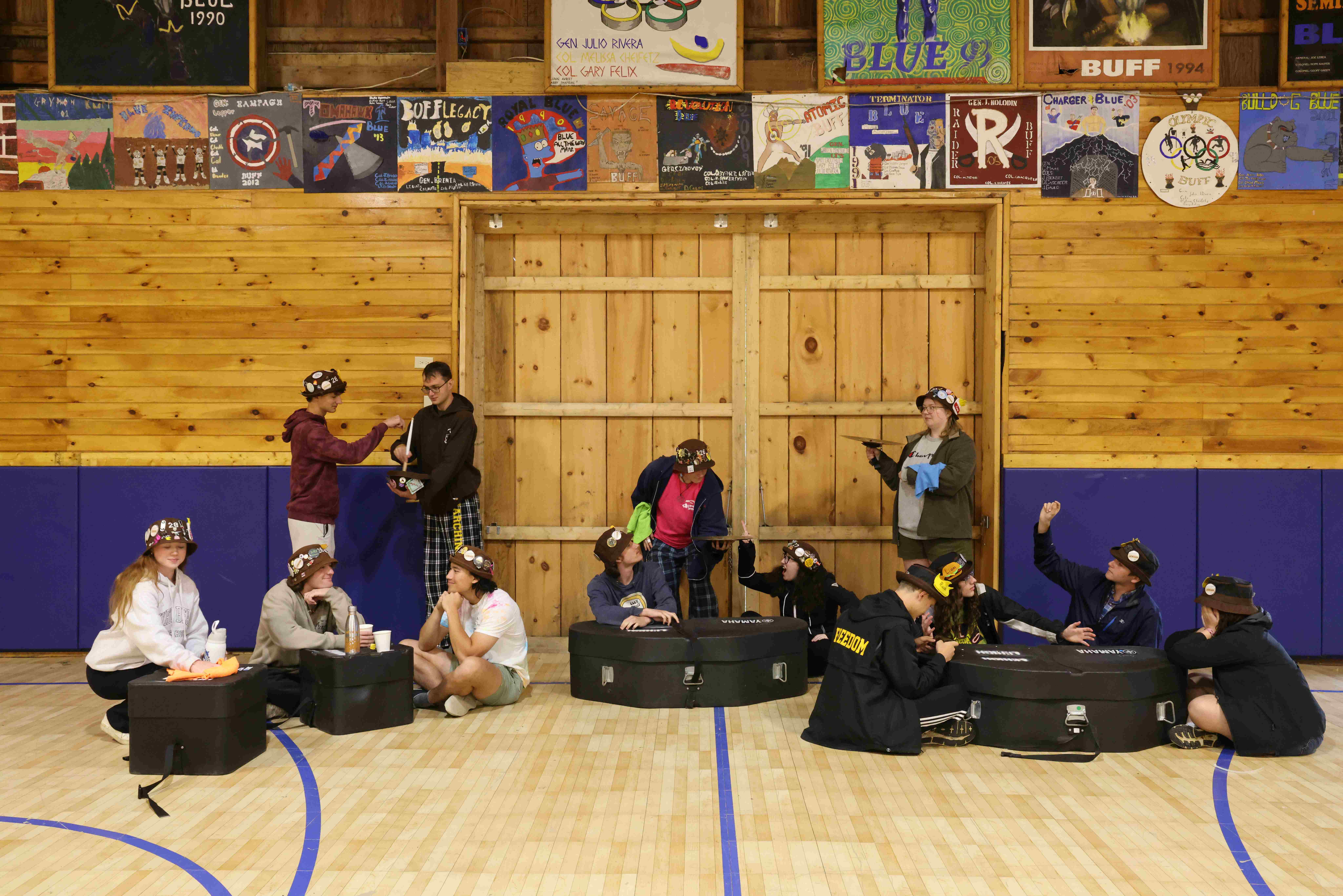 Ranks 3 and 12 pretending to be at a restaurant by using drum cases as tables and cymbals as plates.